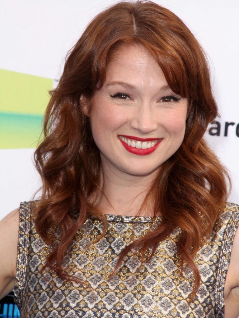 Ellie Kemper with curly red hair with a side fringe