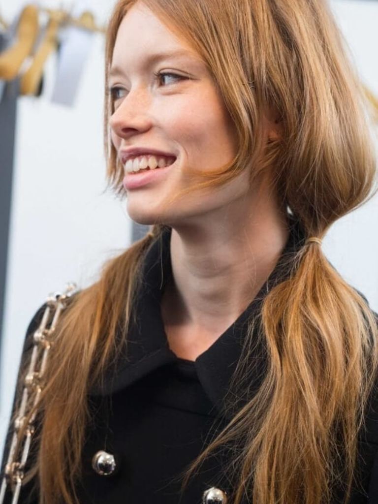 model with loose pigtails and a rose gold hair colour