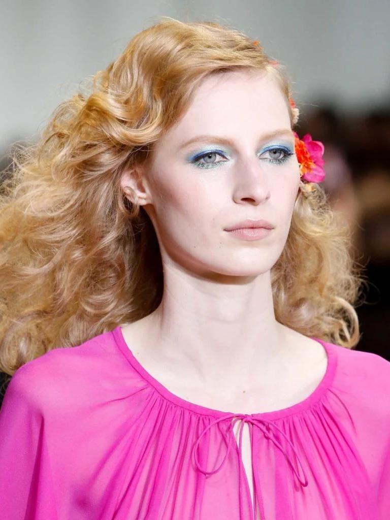 DVF model with strawberry blonde hair and large bouncy curls on runway