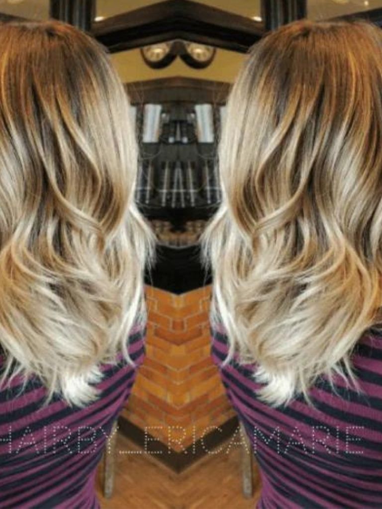 Back view of a womans head with wavy hair - dark roots and honey blonde hair colour