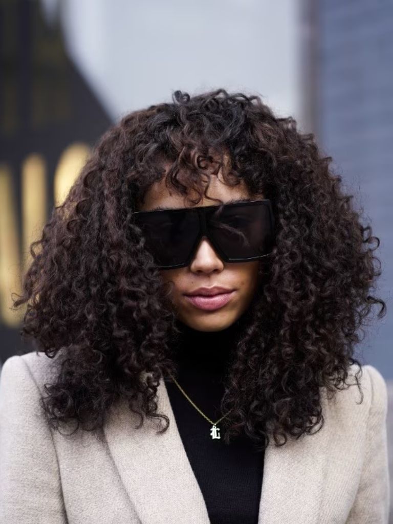 woman with natural curly hair and a fringe