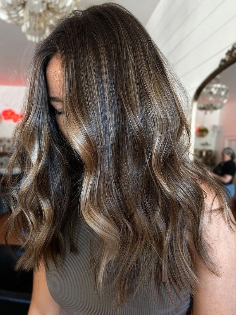 Woman with wavy hair and a cool brown balayage