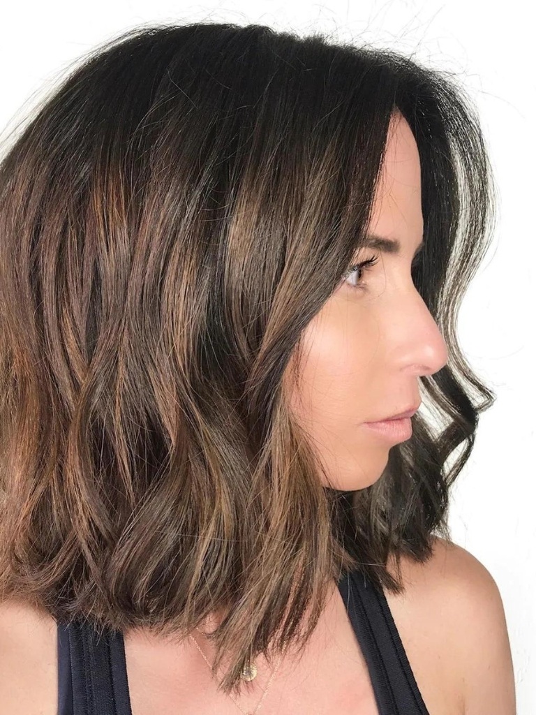 Woman with long bob haircut with light chocolate balayage highlights in it