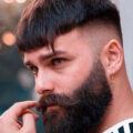 Man with bowl haircut with skin fade and full beard, plus asymmetric fringe