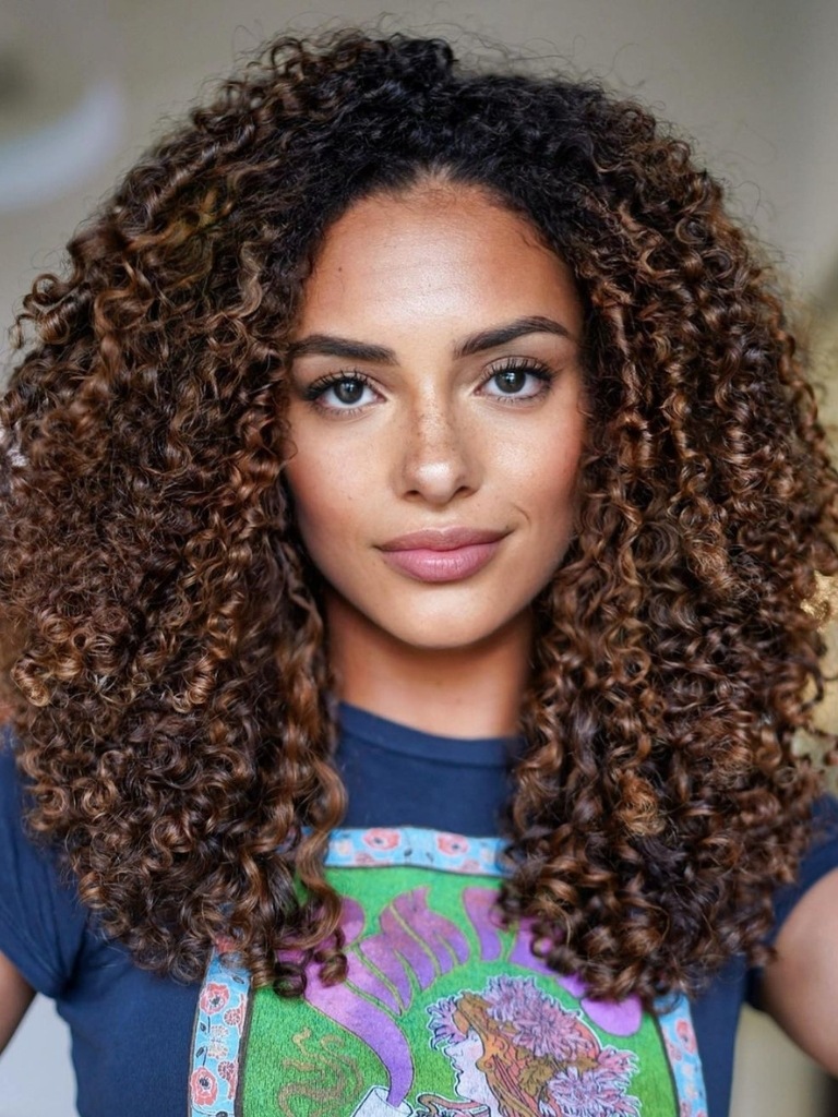 Woman with curly hair and brown balayage