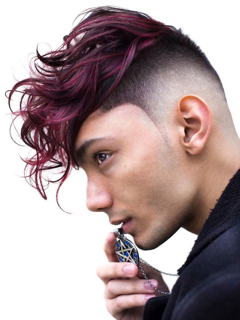Young man with high fade and long tousled top tinted purple with balayage. Kisses medallion