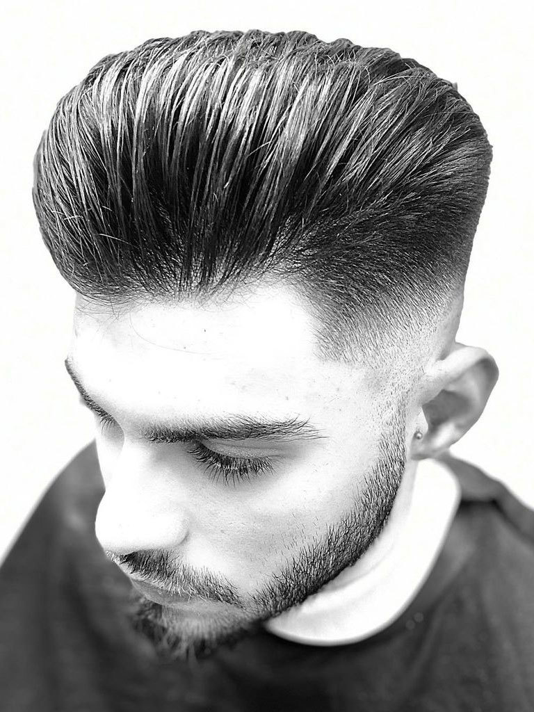Man with high pompadour, slicked back with pomade. With taper and fade.