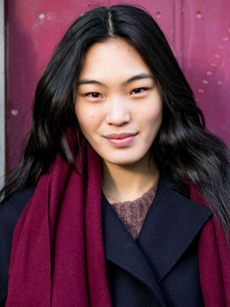 Asian hairstyles: Asian woman with dark brown wavy hair wearing a winter coat and scarf.