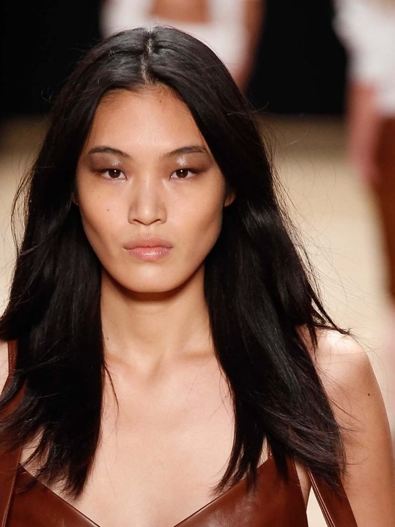 Asian hairstyles: Asian woman with dark brown hair with layers on runway.