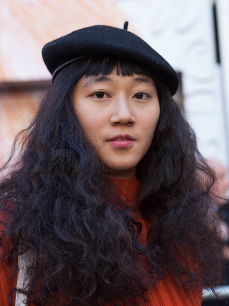 Woman with thick and long curly hair wearing a beret