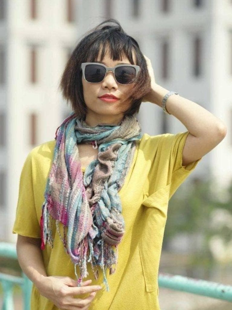 Asian hairstyles: Asian woman with bob and bangs with crimped finish wearing sunglasses.