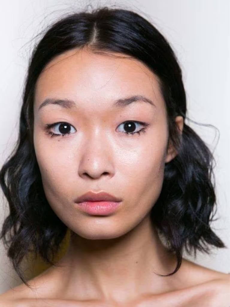 Asian hairstyles: Asian woman with dark brown wavy long bob.
