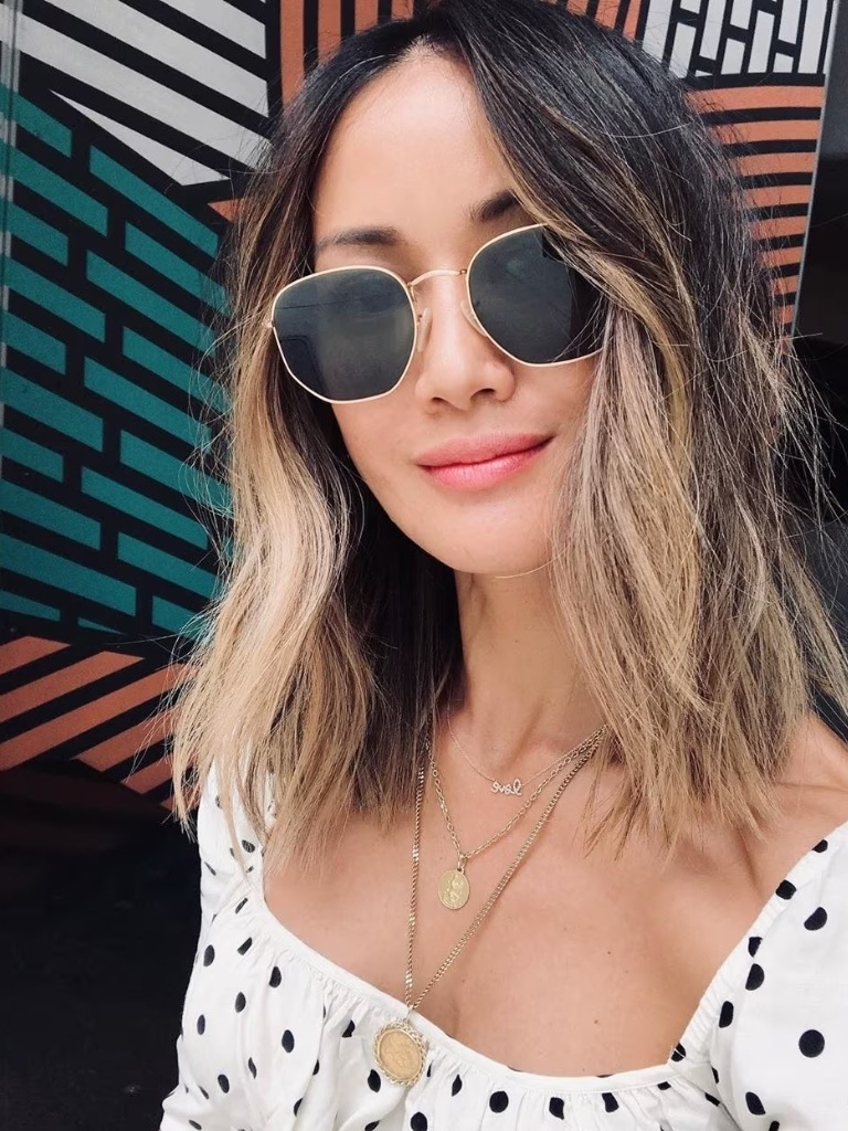 Woman with Asian medium length blonde ombre haircut with layers in it