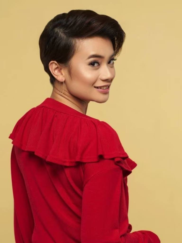 Asian hairstyles: Asian model with short dark brown long pixie wearing a red top.