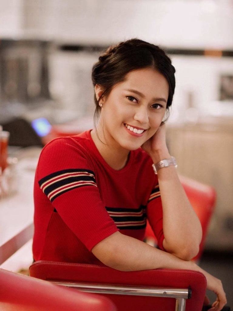 Asian hairstyles: Asian woman with brown hair in crown braid wearing a red top.