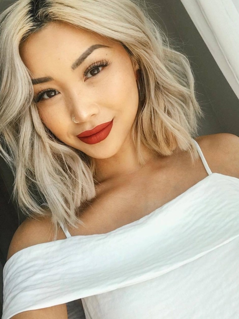Asian woman with blonde curly long bob haircut