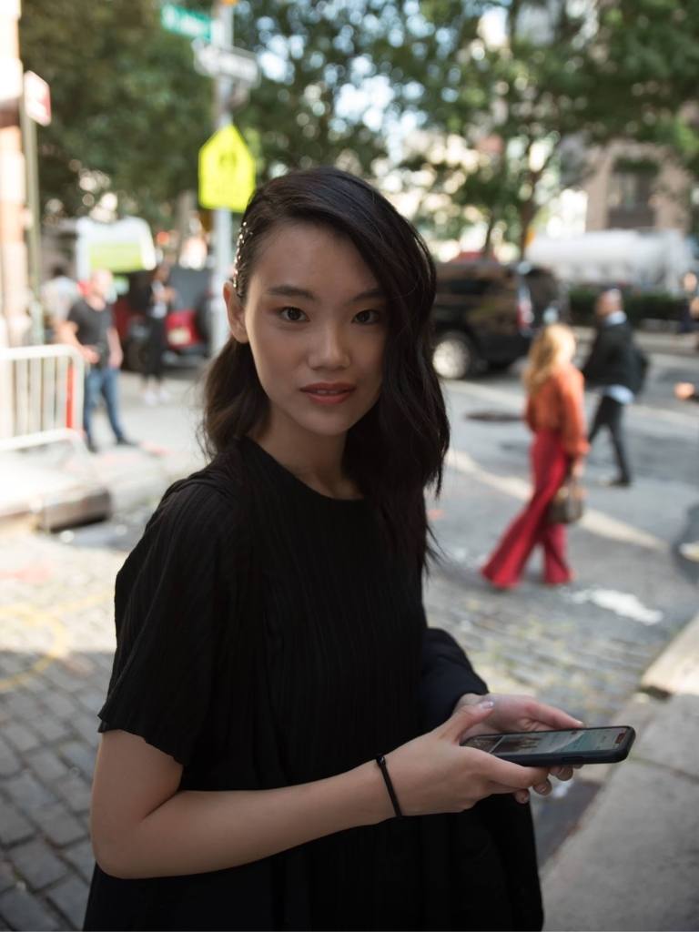 Woman with shoulder length dark Asian hair styled to the side