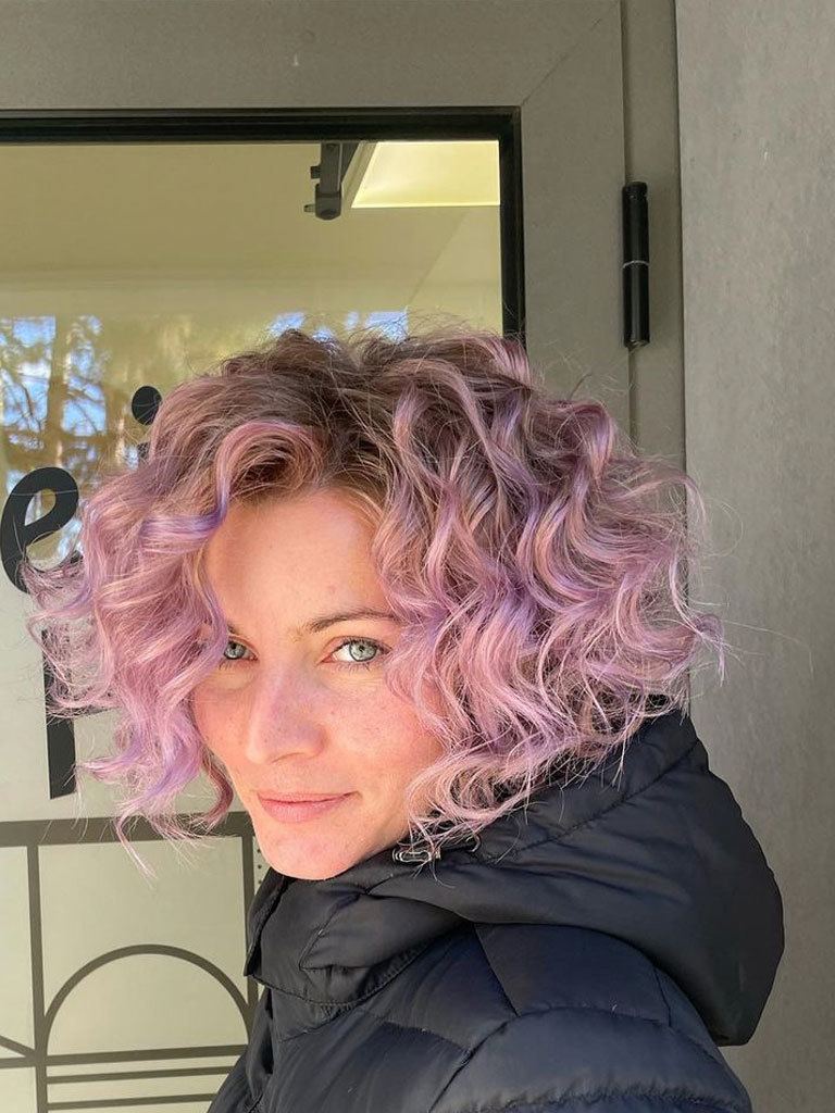 Woman with mauve graduated bob with loose curls