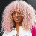 Black woman with thick long spiral permed hairstyle dyed candy floss pink