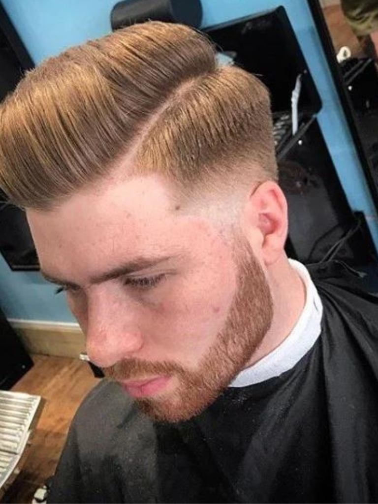 Taper comb over haircut: Barber photo of a ginger man with a comb over taper haircut with facial hair