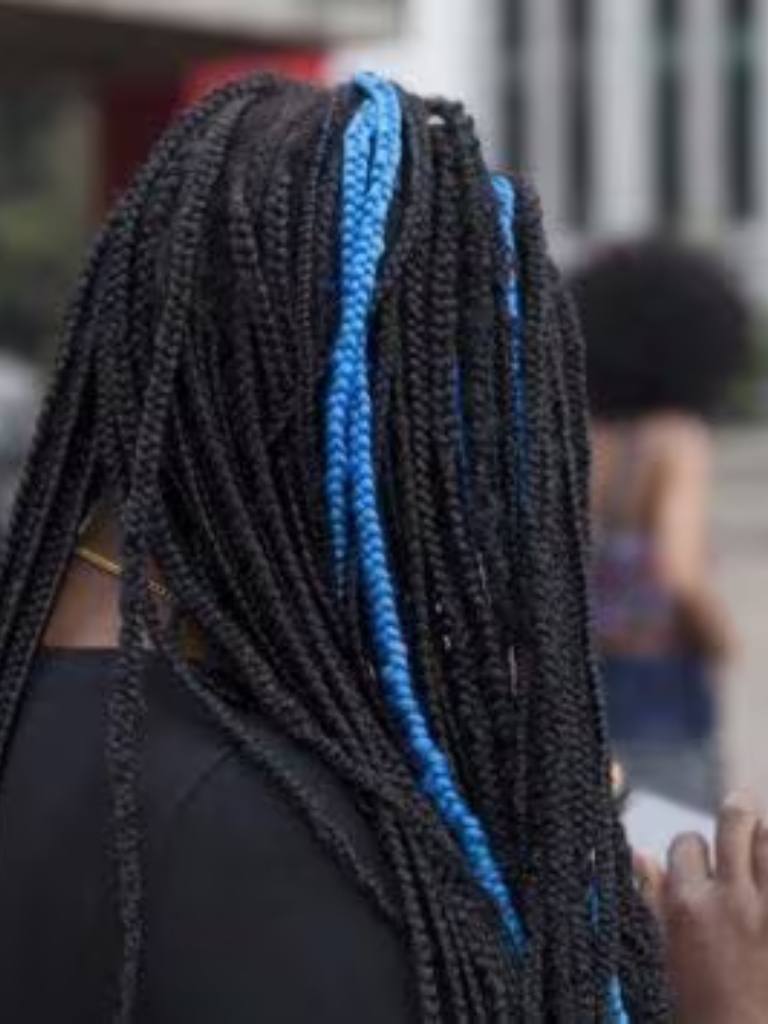back view of a woman with box braids and a streak of blue