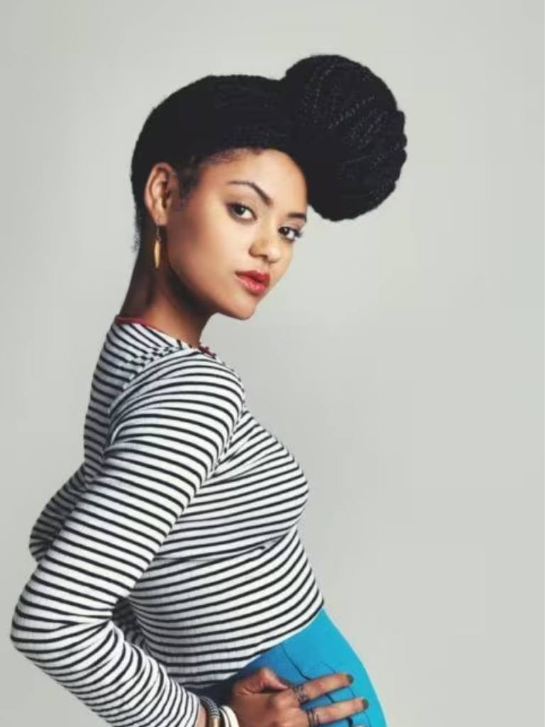 Young black with box braid bun holding her hips