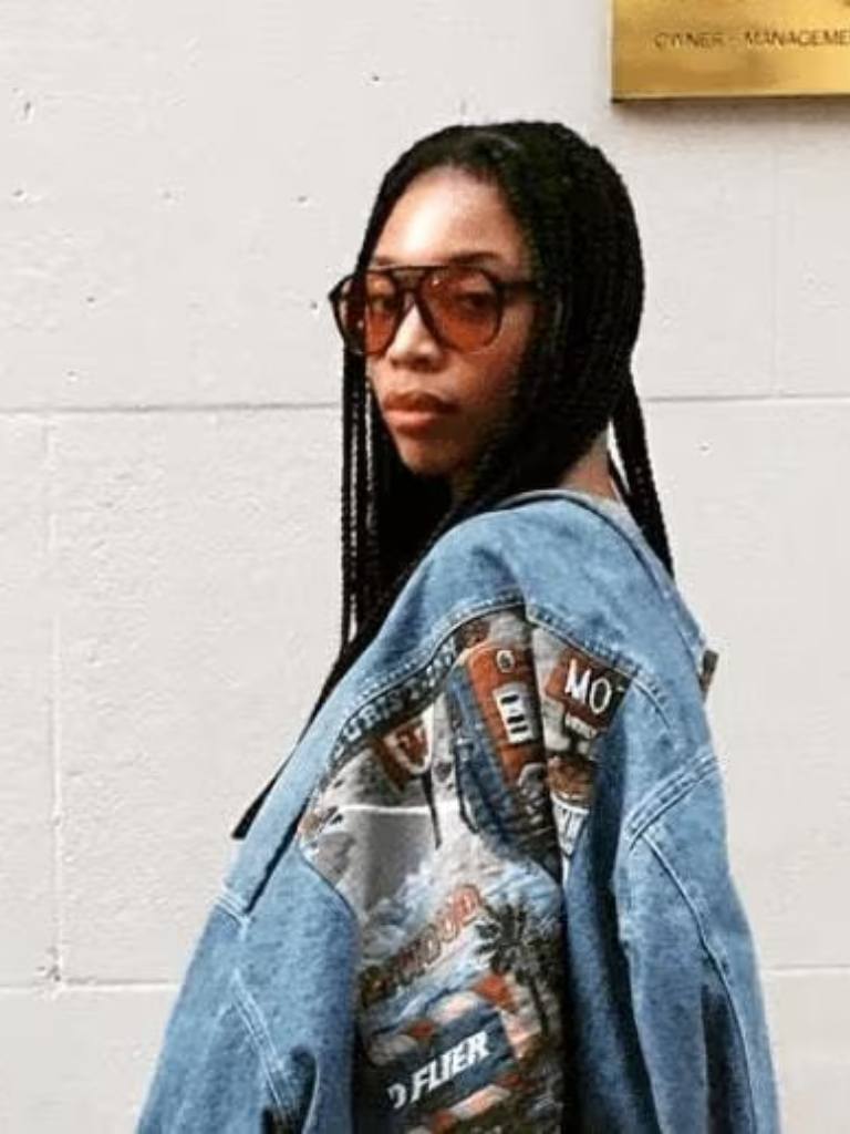 Tierra Lee with long box braids looking over her shoulder