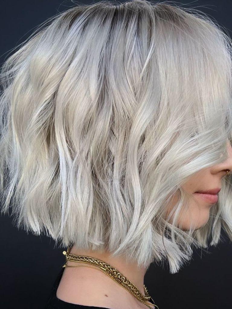 Side view of a woman with a wavy platinum choppy bob