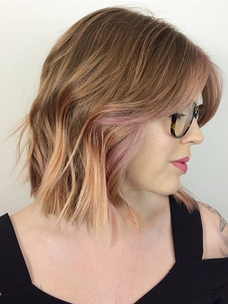 Side view of woman with a long bob and Bardot bangs in brown and blonde hair.