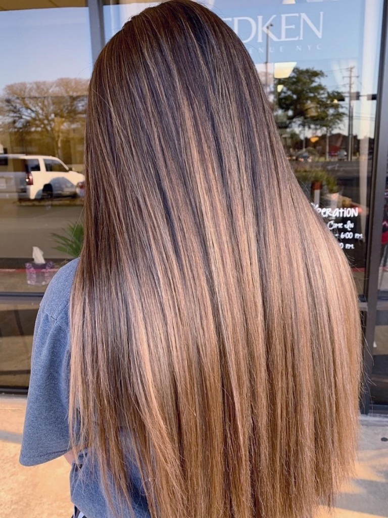 Person with brown balayage on long straight hair