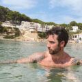 Man in profile swimming in Mediterranean. Hair is cut beautifull with textured and long top, short undercut