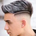 Man with Fauxhawk and grey highlights with deep side part and undercut fade
