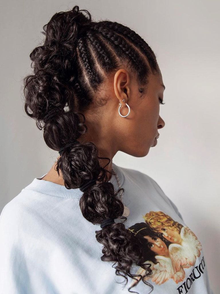 Young black woman viewed from rear showing off her feed-in box braids and high pony with bunched curly hair