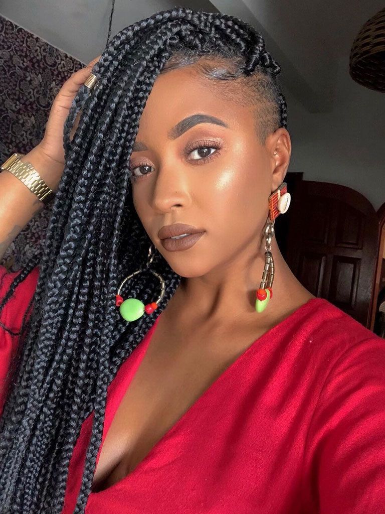 Woman with long box braids and fade at temples with shaved detail