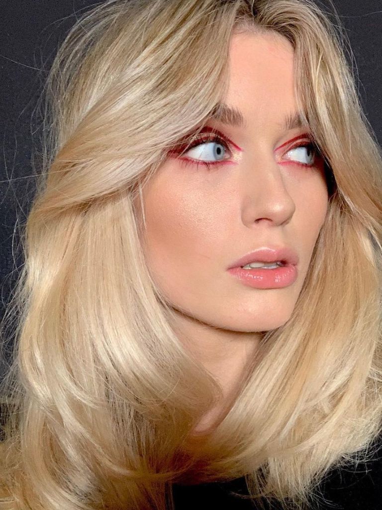 woman with long blonde hair and blown out curtain bangs