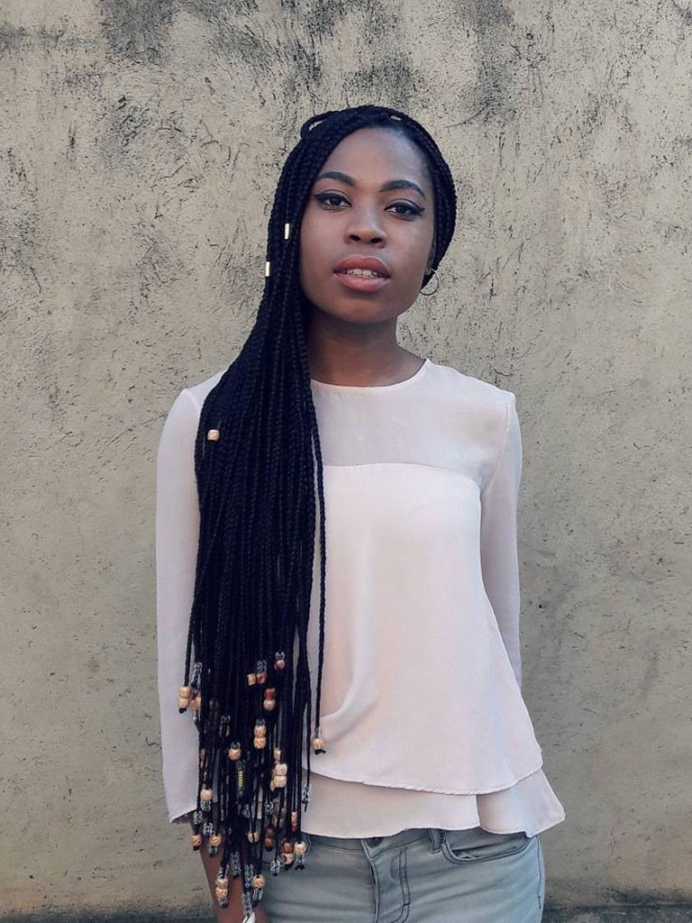 Black woman with long box braids with wooden beaded ends, plus hair cuffs