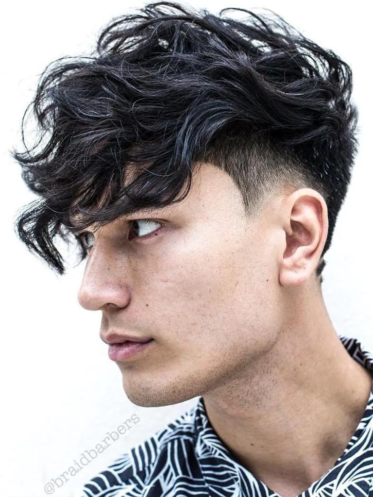 Man with long curly fringe and low undercut fade