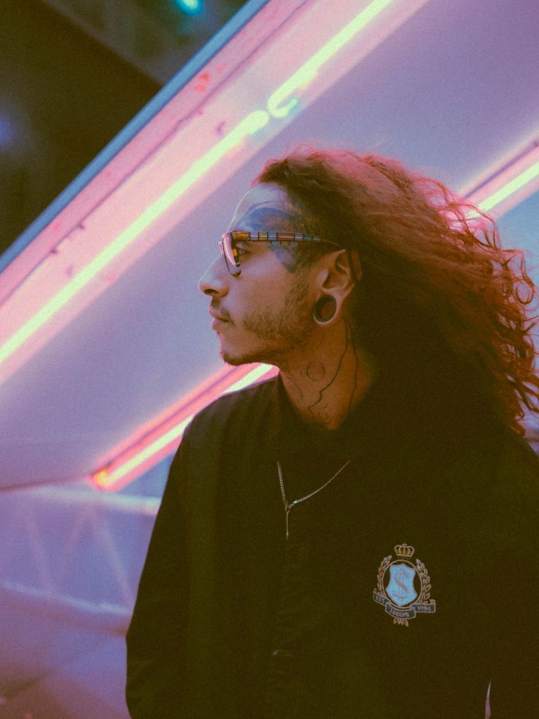 Man with curly long dyed pink hair with undercut