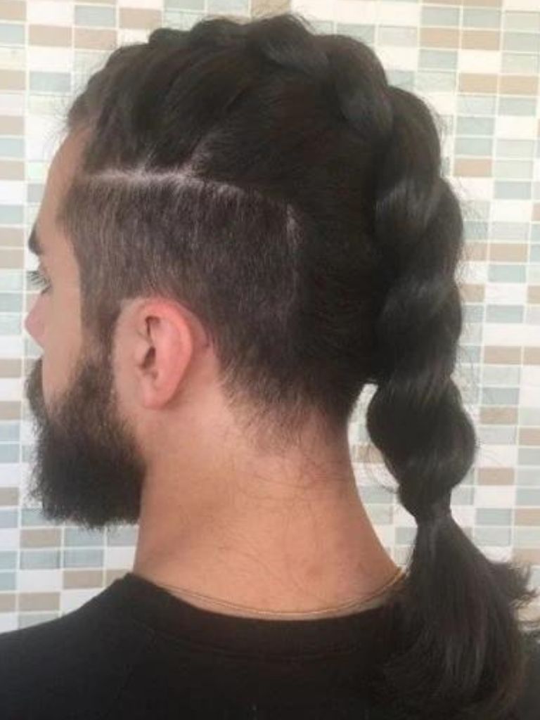 back view of a man with dark long hair in a braided ponytail with an undercut