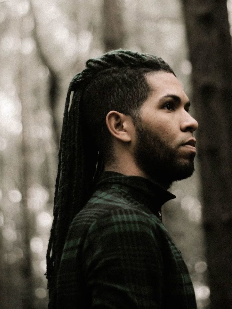 Black man with long braids with taper undercut