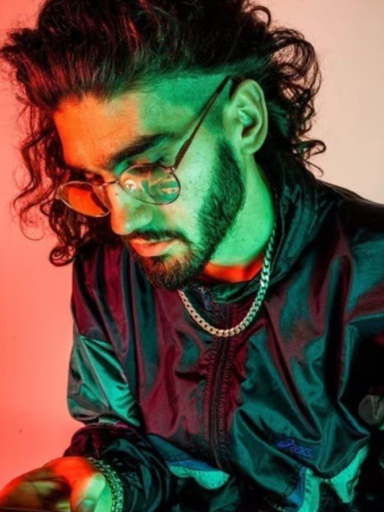 coloured photo of a man with long curly hair and an undercut