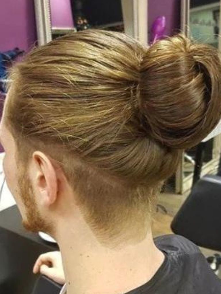 man with a brunette man bun with shaved undercut detail