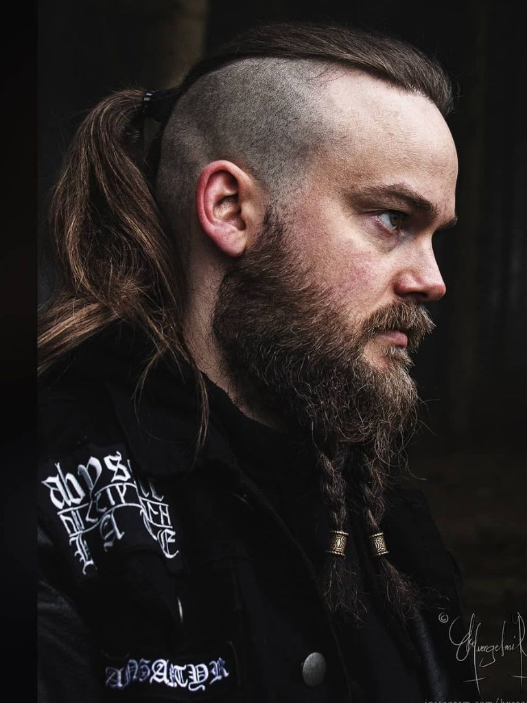Man with disconnected undercut haircut with long hair styled into a ponytail and beard
