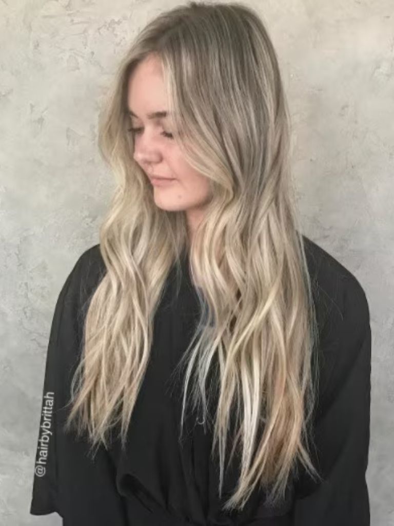 Side profile of a woman with long golden blonde ombre hair