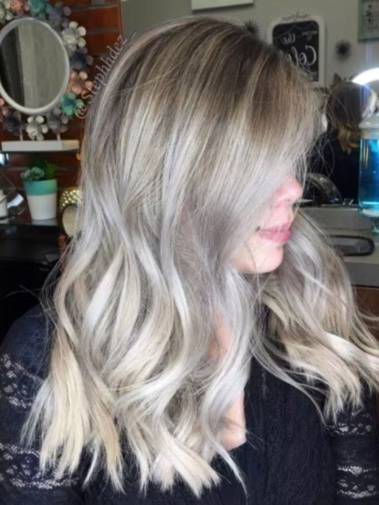 Side profile shot of a woman with medium length curly lilac blonde hair