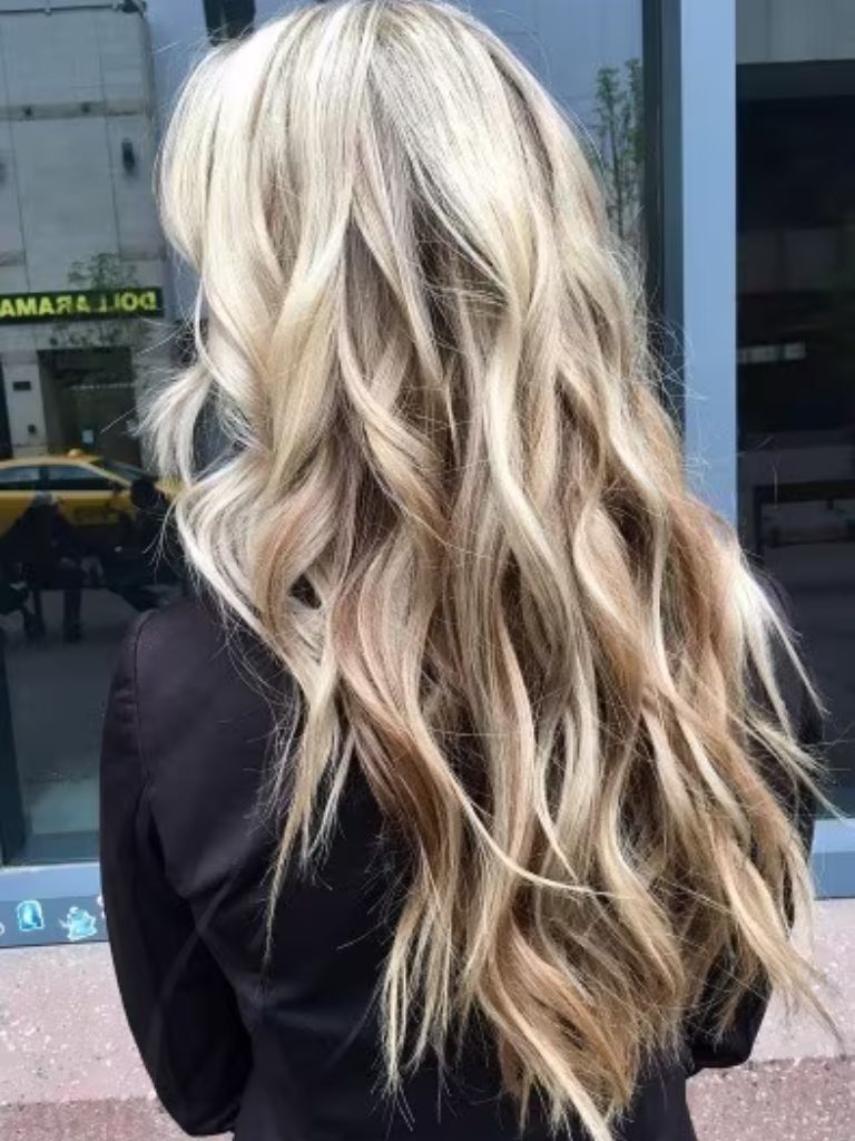 Back view of a woman with waist length reverse blonde ombre hair