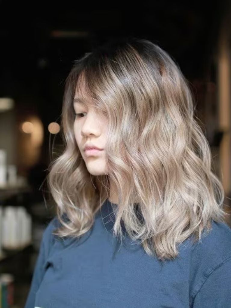 Photo of a woman with shoulder length wavy ash brown ombre hair