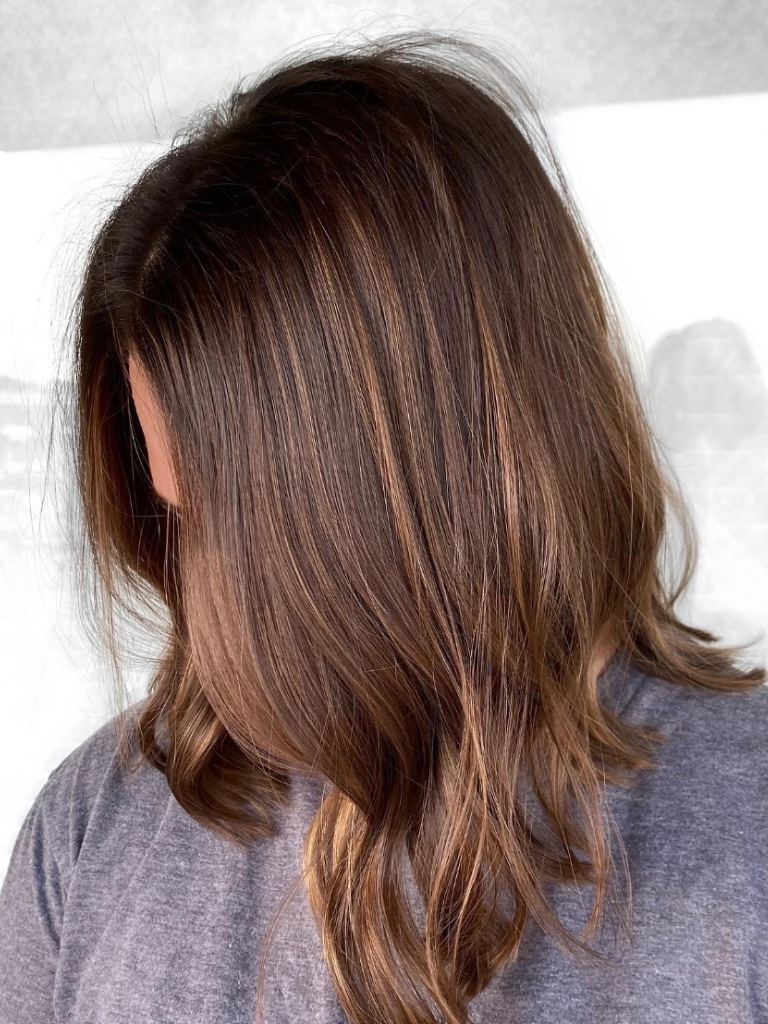 Woman with sunkissed mid-length bob hairstyle with gold highlights