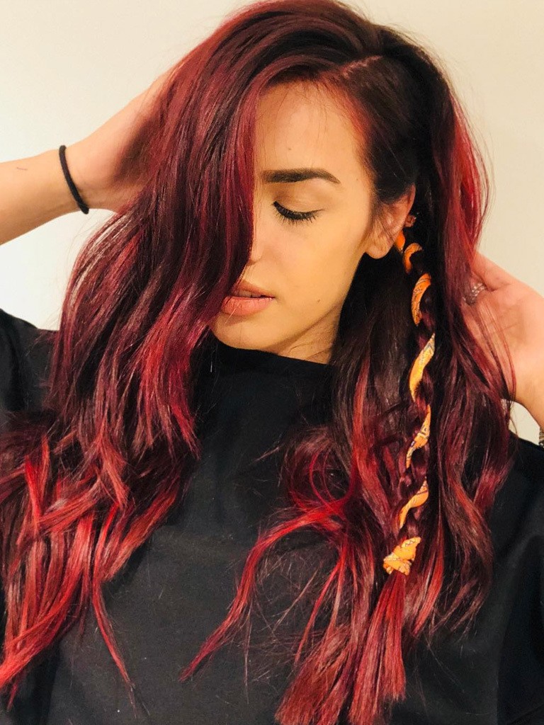 woman with long black and red balayage hair