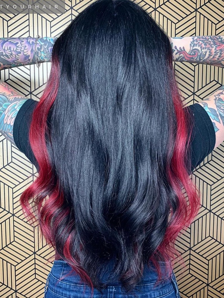 Woman with long black hair with red side highlights